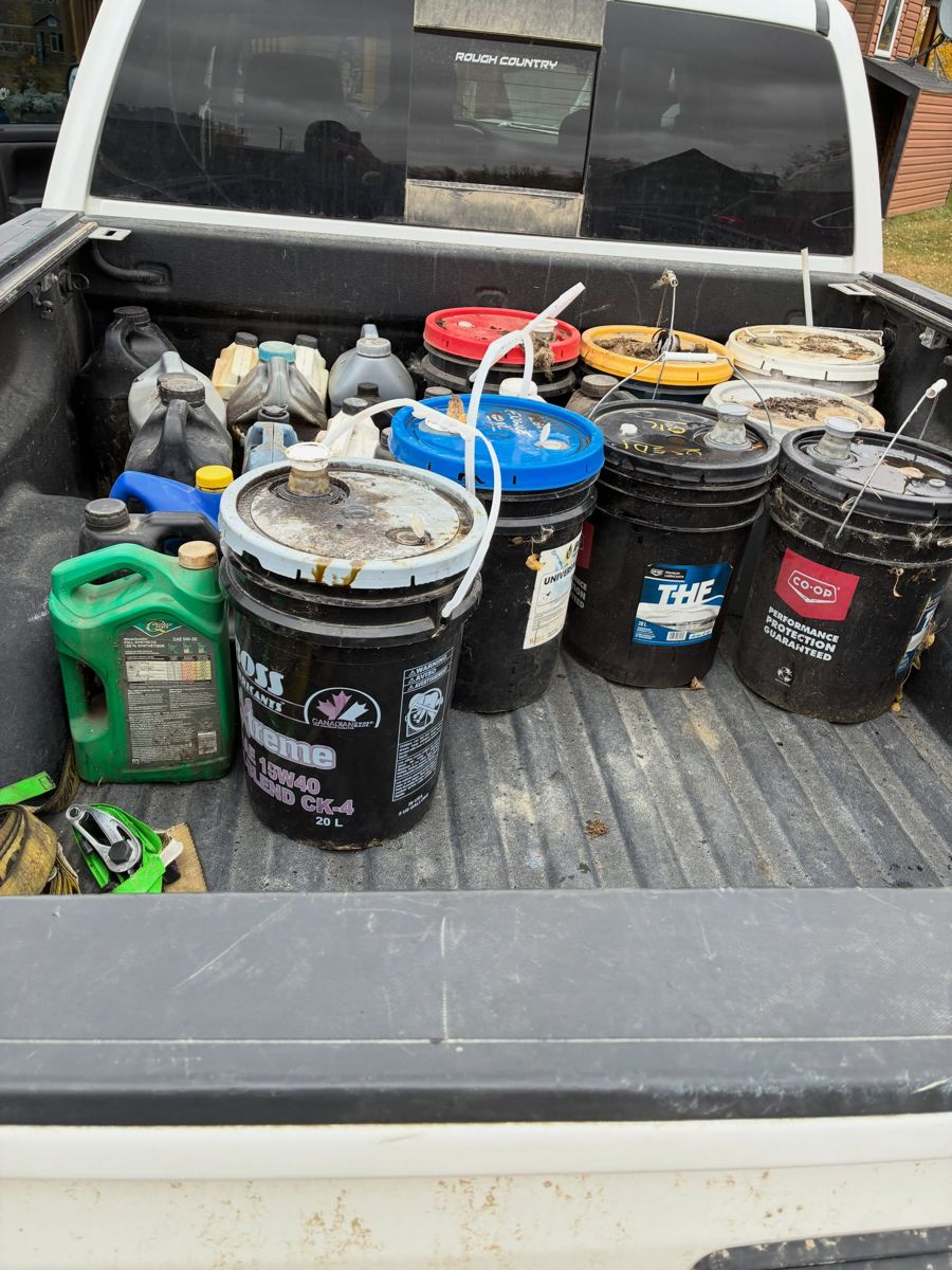 Used oil pails and containers loaded in a truck bed